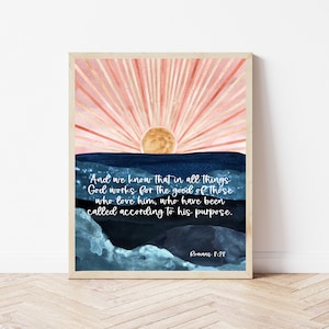 May include: A watercolor painting of a sunrise over a blue and teal ocean with the Bible verse "And we know that in all things God works for the good of those who love him, who have been called according to his purpose. Romans 8:28" printed in white.
