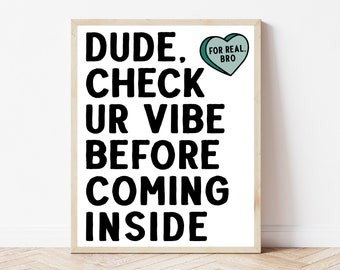 May include: A white framed print with black text that reads "DUDE, CHECK UR VIBE BEFORE COMING INSIDE". A small teal heart with the text "FOR REAL, BRO" is in the top right corner.