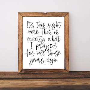 May include: A framed print with a white background and black text that reads "It's this right here. This is exactly what I prayed for all those years ago."
