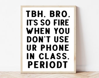 May include: A framed print with the text "TBH, BRO. IT'S SO FIRE WHEN YOU DON'T USE UR PHONE IN CLASS. PERIODT" in bold black letters on a white background. The frame is a light brown color.