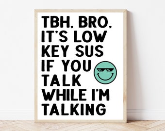 May include: A white framed print with black text that reads "TBH. BRO. IT'S LOW KEY SUS IF YOU TALK WHILE I'M TALKING". A green smiley face with sunglasses is next to the text.