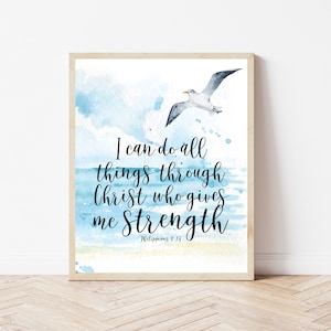 Könnte beinhalten: Ein Aquarelldruck mit einer blauen und weißen Meereslandschaft und einer Möwe, die darüber fliegt. Der Druck zeigt das Zitat "Ich kann alles durch Christus, der mir Kraft gibt" mit dem Bibelvers "Philipper 4,13".