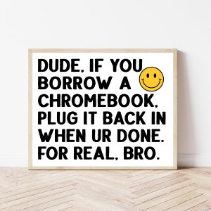 May include: A white framed print with black text that reads "DUDE, IF YOU BORROW A CHROMEBOOK. PLUG IT BACK IN WHEN UR DONE. FOR REAL, BRO." A yellow smiley face is next to the text.