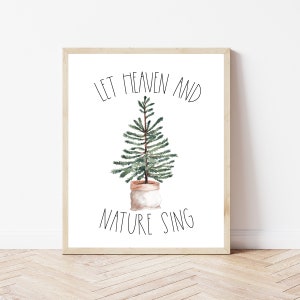May include: A framed print with a white background and black text that reads "Let Heaven and Nature Sing". A small potted evergreen tree is centered in the print.
