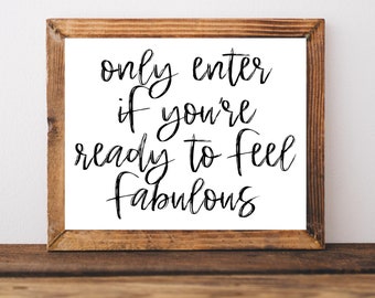 May include: A framed sign with the text "only enter if you're ready to feel fabulous" in black cursive lettering on a white background.