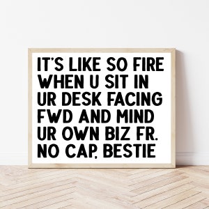 May include: Black and white text on a white background in a wooden frame. The text reads: "IT'S LIKE SO FIRE WHEN U SIT IN UR DESK FACING FWD AND MIND UR OWN BIZ FR. NO CAP, BESTIE"