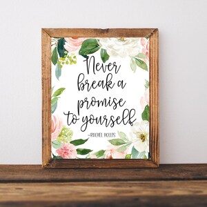 Op de afbeelding: Een ingelijst print met een witte achtergrond en een bloemenontwerp in roze en groene tinten. De quote "Never break a promise to yourself - Rachel Hollis" is gedrukt in zwarte tekst.
