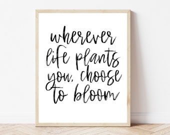 May include: Black and white typography print with the quote "Wherever life plants you, choose to bloom".
