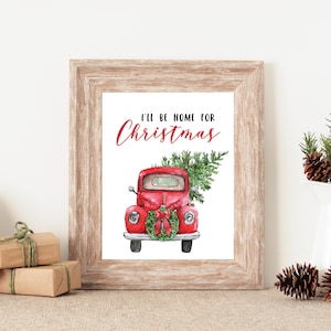 Puede incluir: Un cami&oacute;n vintage rojo con un &aacute;rbol de Navidad en la parte trasera y una corona en la parte delantera. El texto "I'll be home for Christmas" est&aacute; escrito en rojo sobre el cami&oacute;n.