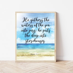Könnte beinhalten: Ein gerahmter Aquarelldruck mit einem blauen und weißen Meereslandschaft Hintergrund. Der Druck zeigt ein Zitat aus Psalm 33,6-7: "Er sammelt die Wasser des Meeres in Krüge: er legt die Tiefe in Vorratskammern."