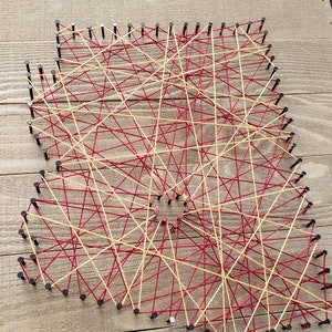 May include: A string art piece with red and yellow string wrapped around nails hammered into a wooden board.