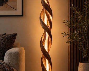 Może przedstawiać: Wysoka lampa podłogowa z ciemnobrązową drewnianą ramą o spiralnym, skręconym kształcie, który wygina się ku górze. Konstrukcja otacza centralne pionowe źródło światła, które emituje ciepły, miękki blask, oświetlając słoje drewna.