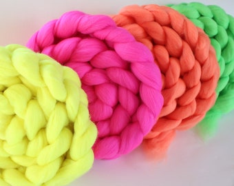 May include: Four round, braided yarn circles in bright neon colors: yellow, pink, orange, and green.