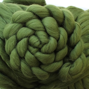 May include: Close-up of olive green chunky knit yarn, arranged in a spiral pattern. The thick, soft wool is ideal for creating cosy blankets, scarves, and other home decor items. The texture of the yarn is clearly visible.
