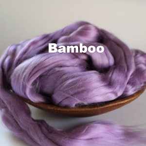Peut inclure: Une pile de fibres de bambou de couleur lavande, pr&eacute;sent&eacute;e dans un petit bol en bois. Le texte "Bamboo" est superpos&eacute; sur la fibre. La fibre a un aspect doux et soyeux, id&eacute;al pour les projets d'artisanat et textiles.