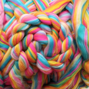 May include: A close-up of a rainbow-colored roving yarn, with strands of yellow, pink, blue, and white.