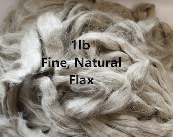 May include: A close-up of a pile of natural, fine flax fibers. The fibers are a light beige color and are arranged in a loose, tangled mass. The text "1lb Fine, Natural Flax" is visible on the fibers.