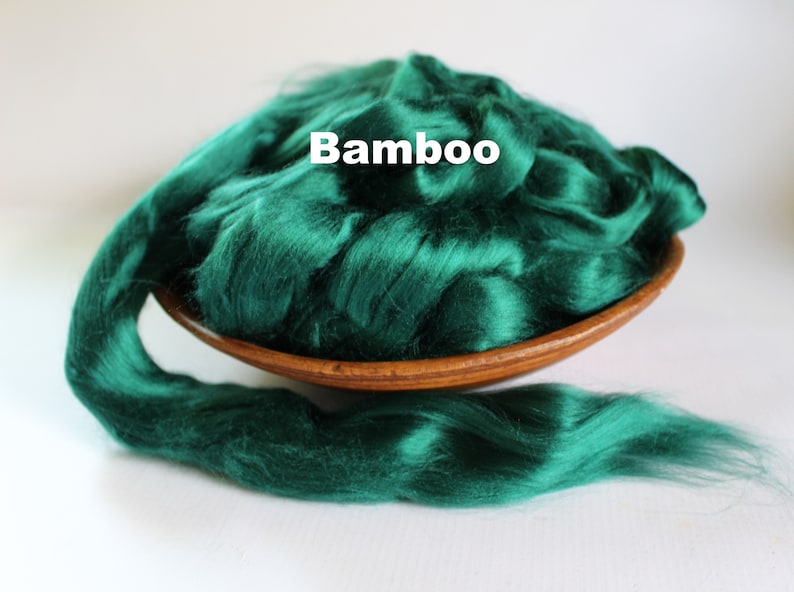 May include: A bowl of emerald green bamboo fiber, also known as bamboo silk, with a strand of the fiber extending out of the bowl.