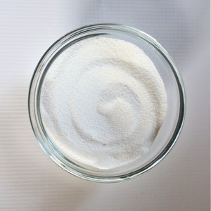 May include: A clear glass bowl filled with white powder, likely powdered sugar or cornstarch.