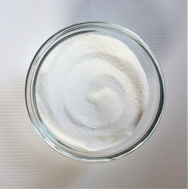 May include: A clear glass bowl filled with white powder, likely powdered sugar or cornstarch.
