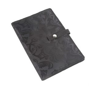 May include: Black fabric wallet with a floral pattern and a snap closure.