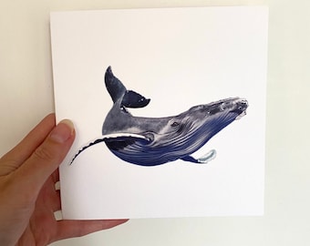 May include: A square print featuring a detailed illustration of a humpback whale in shades of blue and gray. The whale is depicted swimming, with its tail and flipper visible. The artwork is on white paper.