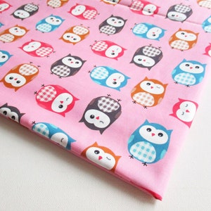 May include: Pink fabric with a repeating pattern of colorful owls. The owls have different colored bodies, wings, and eyes.