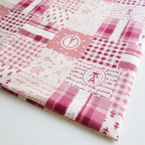 May include: Pink and white fabric with a patchwork design featuring a checkered pattern, floral accents, and a repeating phrase in French. The fabric also includes a small image of the Eiffel Tower.