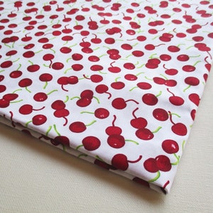 Puede incluir: Tela blanca con un patrón repetido de cerezas rojas. Las cerezas están dibujadas en un estilo simple y de dibujos animados.