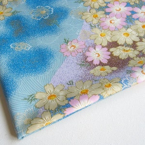 May include: A blue and purple fabric with a floral pattern. The flowers are pink, white, and yellow. The fabric has a subtle wave pattern.
