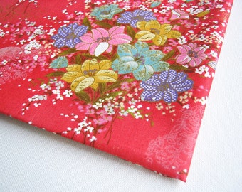 May include: Red fabric with a floral pattern featuring pink, blue, yellow, and white flowers. The fabric has a subtle shimmer and a delicate texture.