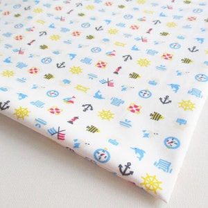 May include: White fabric with a repeating pattern of nautical themed icons. The icons include anchors, compasses, steering wheels, sailboats, lighthouses, and fish. The icons are in shades of blue, red, yellow, and black.