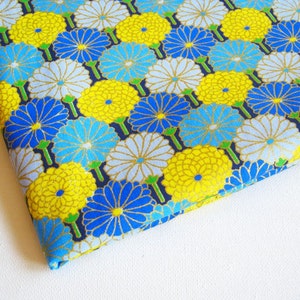 May include: Blue, yellow, and white floral fabric with a repeating pattern of chrysanthemums. The fabric has a subtle shimmer and is perfect for crafting projects.