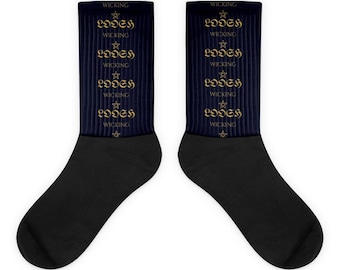 Könnte beinhalten: Ein Paar dunkelmarineblaue Socken mit einem sich wiederholenden Muster aus goldenen Sternen und dem Text "LOOSH" und "WICKING", der vertikal in einer gotischen Schriftart auf dem gerippten oberen Teil aufgedruckt ist.