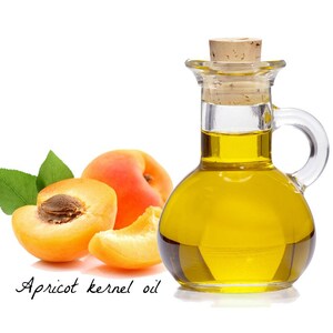 May include: A glass bottle with a cork stopper filled with golden yellow apricot kernel oil.  Three apricot halves are next to the bottle, two are whole and one is cut open.  The text "Apricot kernel oil" is written below the image.