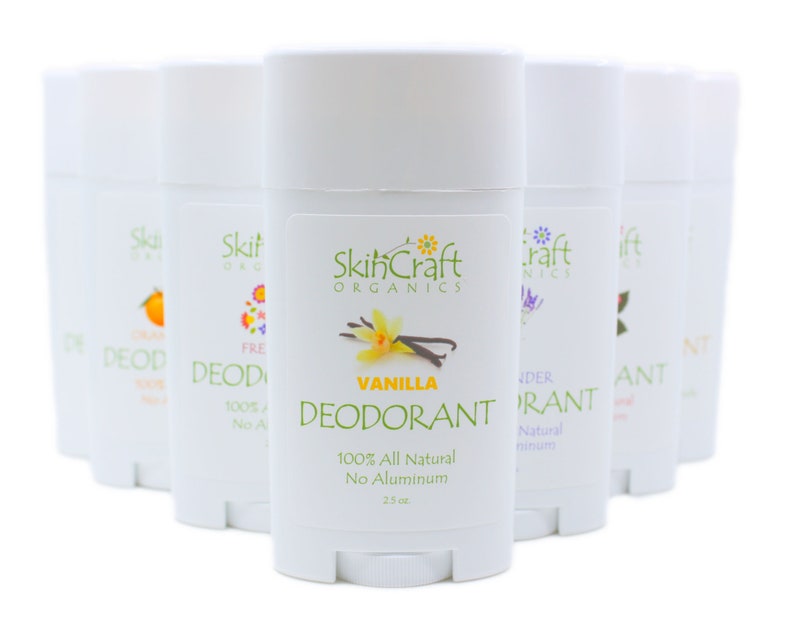 May include: A row of eight white deodorant sticks with different scents, including vanilla, lavender, and orange. The sticks are labeled "SkinCraft Organics" and say "100% All Natural No Aluminum".