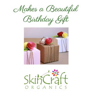 May include: Three small gift boxes wrapped in brown paper with twine and topped with pink and white paper flowers. The boxes are sitting on a white surface. The text "Makes a Beautiful Birthday Gift" is above the boxes and the text "SkinCraft Organics" is below the boxes.