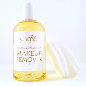 May include: A clear glass bottle with a white pump top and a white label. The label says "SkinCraft Organics, Gentle & Unscented Makeup Remover, 4 fl oz".