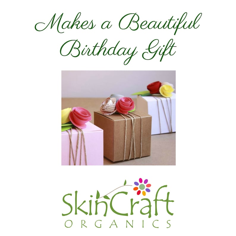 May include: Three gift boxes wrapped in brown, white, and pink paper with twine and topped with pink paper flowers. The boxes are arranged on a white surface. The text "Makes a Beautiful Birthday Gift" is above the boxes and the text "SkinCraft Organics" is below the boxes.