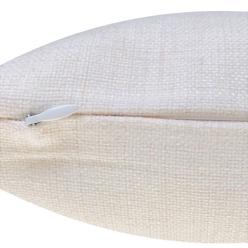 May include: A white pillow cover with a zipper closure. The zipper is visible and has a white pull tab.