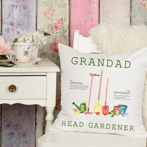 May include: White cushion with green text that reads "Grandad Head Gardener". The cushion features a watercolour illustration of gardening tools, a bird, and the words "Garden" and "Gardener" with definitions.