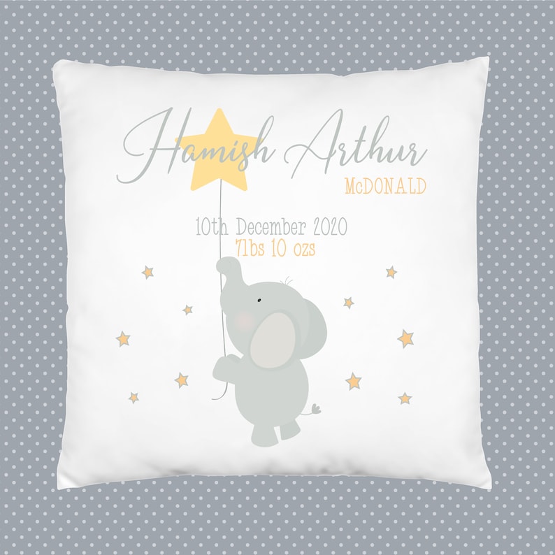 May include: A white pillow with a yellow star, a gray elephant holding the star, and the text "Hamish Arthur MCDONALD 10th December 2020 7lbs 10 ozs" printed on it.