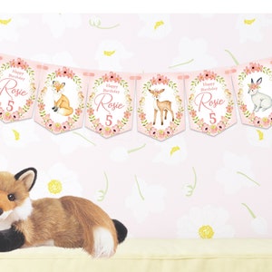 Op de afbeelding: Roze en witte banner met illustraties van bosdieren en de tekst "Happy Birthday Rosie 5".
