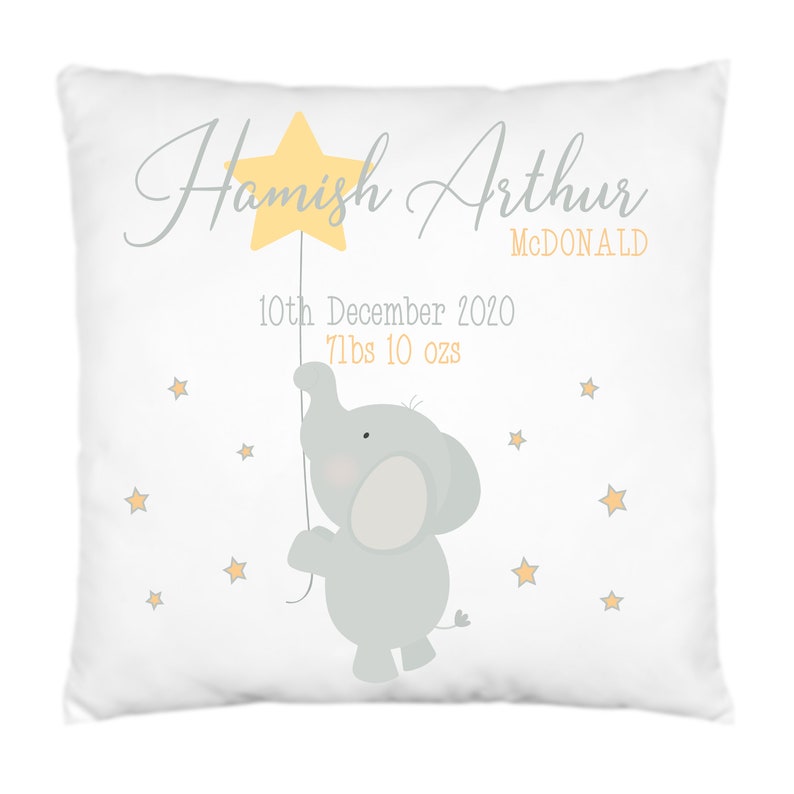 May include: A white pillow with a gray elephant holding a yellow star. The pillow has the text "Hamish Arthur McDonald" and "10th December 2020 7lbs 10 ozs" printed on it.