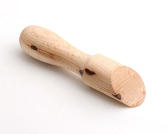 May include: A wooden spoon with a rounded handle and a scoop-shaped head. The spoon is made of light-colored wood with dark brown streaks.