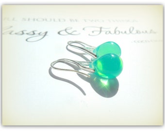 May include: A pair of silver teardrop earrings with light turquoise glass drops.