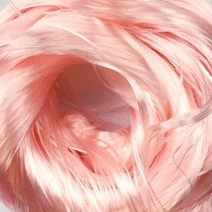 Könnte beinhalten: Ein Bündel weiches, hellrosa Garn. Das Garn ist locker gewickelt und hat einen dezenten Glanz.