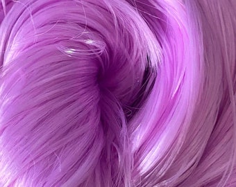 May include: Close-up of a bundle of soft, light purple yarn. The yarn is made of fine fibers and has a silky texture.