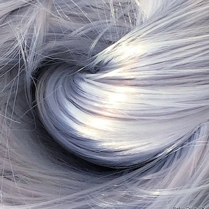 Op de afbeelding: Een close-up van een bundel zilvergrijze synthetische haarvezels. De vezels zijn zacht en zijdeachtig, met een lichte glans.