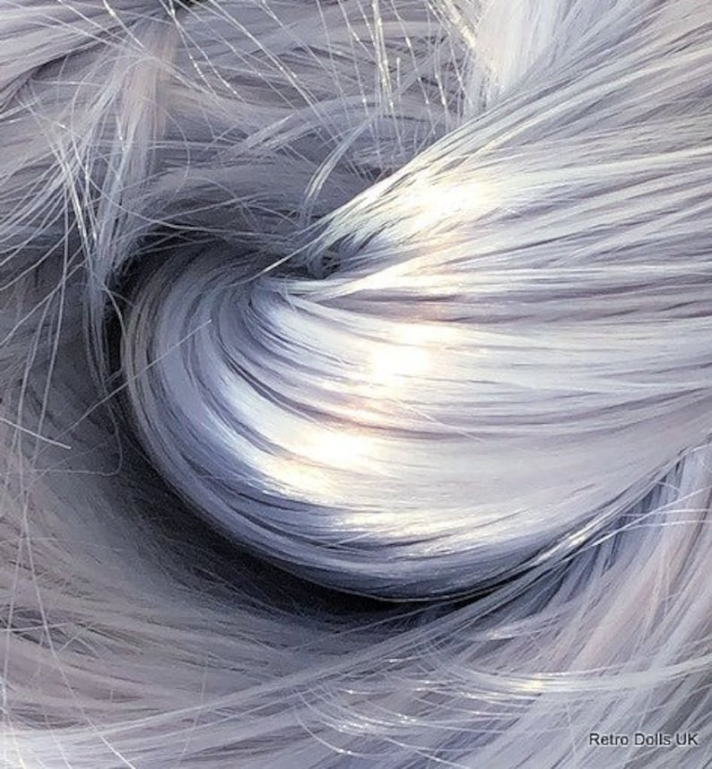Op de afbeelding: Een close-up van een bundel zilvergrijze synthetische haarvezels. De vezels zijn zacht en zijdeachtig, met een lichte glans.